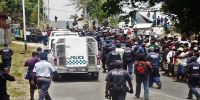 Crowds gather to witness the convicted MP&#039;s inside the escorted Police Vehicle in front of the