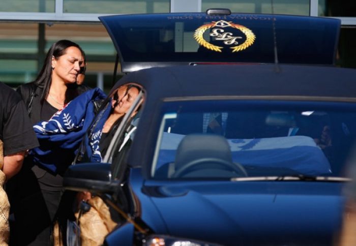 Audra Watts, wife of Kali Fungavaka lays the flag on the casket before the funeral of Constable Kali Fungavaka at the LDS Stake Centre in Otara on August 31, 2012 in Auckland, New Zealand.