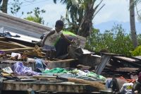 A child crawls in the wreckage of a home destroyed by Tropical cyclone Winston in Fiji